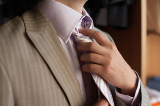 Man adjusting tie. File photo.