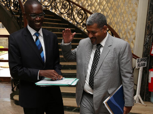 IEBC CEO Ezra Chiloba and Mvita MP Abdulswamad Shariff chat after IEBC commissioners appeared before the Parliamentary Justice and legal affairs committee on February 11.Photo/HEZRON NJOROGE