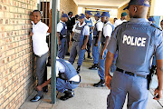 FILE PICTURE: SAPS members search a boy at Ngqayisivele High School in Tembisa, Ekurhuleni. 