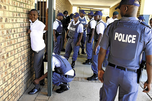 FILE PICTURE: SAPS members search a boy at Ngqayisivele High School in Tembisa, Ekurhuleni.