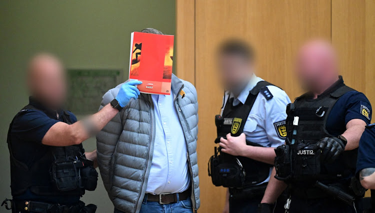 A defendant in handcuffs arrives in court were nine men went on trial charged with high treason, in Stuttgart, Germany, April 29 2024. Picture: Bernd Weissbrod/Reuters