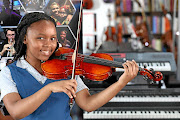 Mbali Phato after receiving a violin from Anthony Franklin of Lovemore Music. The instrument was donated by   a Czech violin maker after it was built by three boys in his workshop.  /ANTONIO mUCHAVE