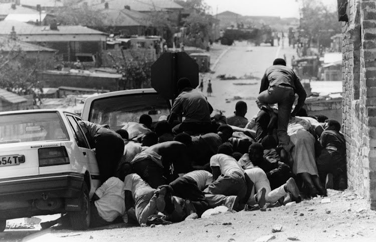 People taking cover after a protest march turned into a gunfight with the Police in Alexandra township , Johannesburg. Pic: 26/03/1992.