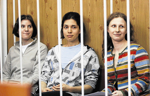 Members of female punk band 'Pussy Riot', Yekaterina Samutsevich (left), Nadezhda Tolokonnikova and Maria Alyokhina sit behind bars before a court hearing in Moscow. File photo.