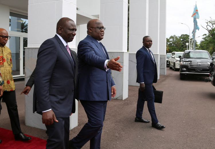 Congolese president Felix Tshisekedi gestures as he walks with his Kenyan counterpart William Ruto after a meeting in Kinshasa on November 21.