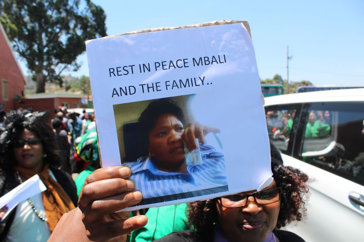 A mourner waves a placard at the funeral of seven members of the Khoza family who were murdered in Vlakfontein, south of Johannesburg.