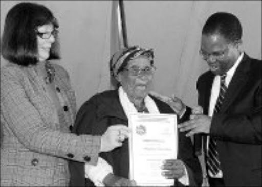 IMPRESSIVE: KwaZulu-Natal premier S'bu Ndebele awarding Bonezinkulu Magubane of Ndumeni, 101, with a certificate, helped by provincial education MEC, Ina Cronje, during the Masifundisane graduation ceremony held at the Royal Show grounds yesterday. Pic. Siyabonga Mosunkutu. 11/09/07. © Sowetan.