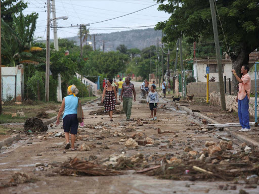 People walk on the street after strong waves hit the coast at Siboney beach ahead of the arrival of Hurricane Matthew in Cuba, October 4, 2016. /REUTERS