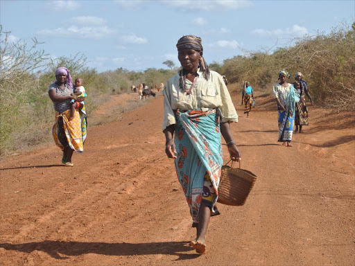 Women walk barefoot to a relief food distribution centre in Ganze, Kilifi county, on July 23 / ALPHONCE GARI