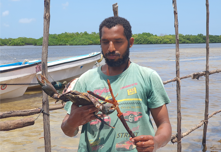 Pate Resources and Tourism Initiative member Swaleh Abdalla with one of the crabs in their farm