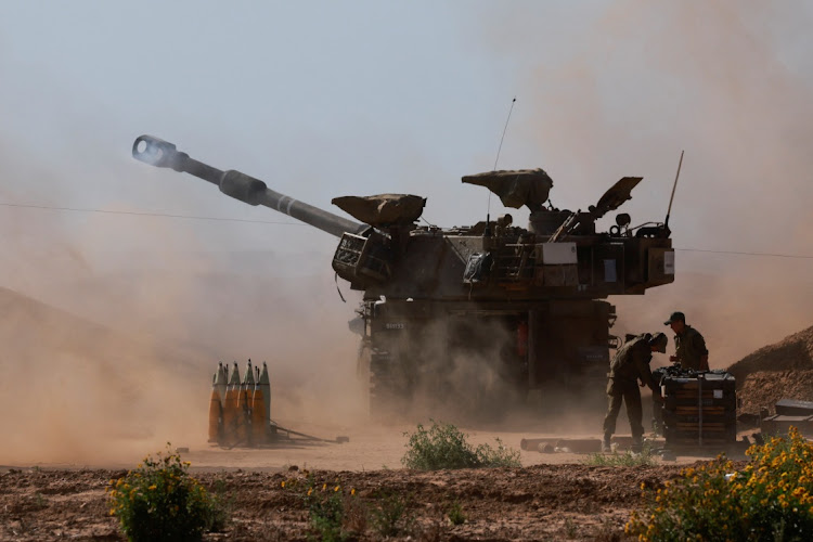 An Israeli military vehicle fires near the Israel-Gaza border, amid the ongoing conflict between Israel and the Palestinian Islamist group Hamas, in southern Israel, on May 8 2024.