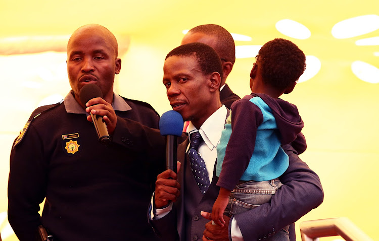 Sergeant Setjakadume Thobejane relays the story of how he saved the three-year-old, who is held by Prophet Mboro, from drowning in a river during a church service on July 1, 2018.