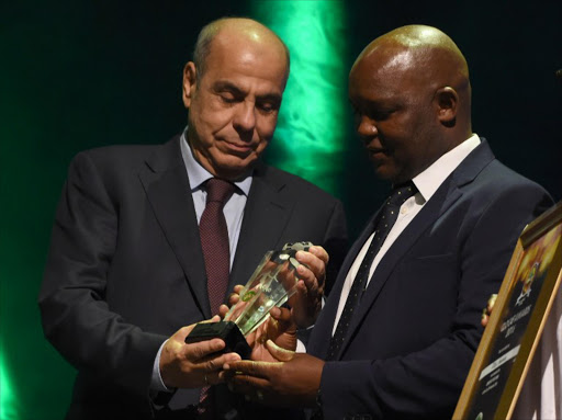 Coach of the Year Mamelodi Sundowns Pitso Mosimane (R) receives his award during the African Footballer of the Year Awards in Abuja, on January 5, 2017. Algerian and Leicester striker Riyad Mahrez was crowned the CAF African best Footballer for 2016 and beating former best player and Gabonese forward Pierre-Emerick Aubameyang and Sehegalese striker Sadio Mane, for the continent's most prestigious individual award. Image by: PIUS UTOMI EKPEI / AFP