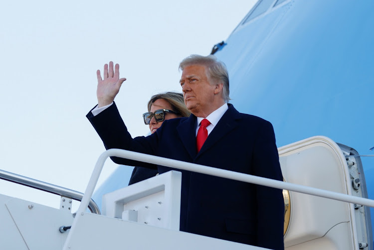 U.S. President Donald Trump, accompanied by first lady Melania Trump, waves as he boards Air Force One at Joint Base Andrews, Maryland, U.S., January 20, 2021.