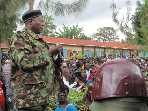 A senior police officer from Nyamira county addresses ODM members at Nyamira primary school during party nominations on Tuesday.Photo Benson Nyagesiba