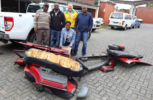 CHOPPED UP: Members of the Cambridge police task team stand alongside Mdantsane preacher Mzontsundu Nokenke, left, with the parts of his stolen Mazda in front of them. Next to Nokenke are, from left, Constable Bulelani Mgubo, Captain Mark McKerry, Constable Zukile Makalama, and Constable Bongiwe Qingalendlela Picture: STEPHANIE LLOYD
