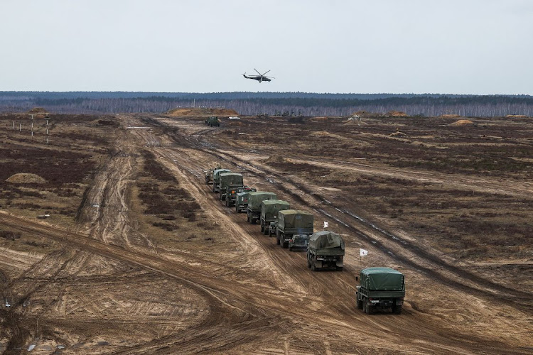 A helicopter flies over troops during the joint military drills of the armed forces of Russia and Belarus at a firing range in the Brest Region, Belarus February 19, 2022.