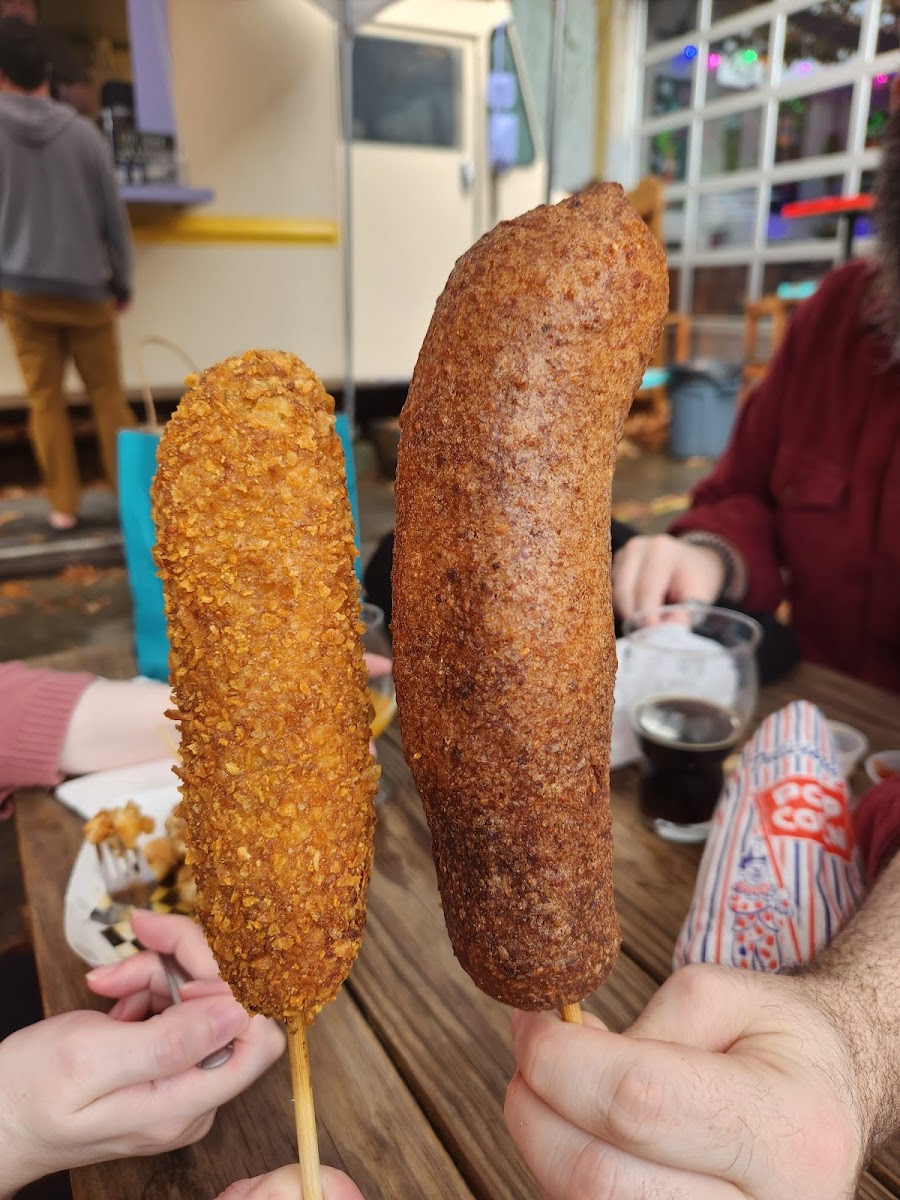 Vegan corn dog left, giant bratwurst right, both chip covered