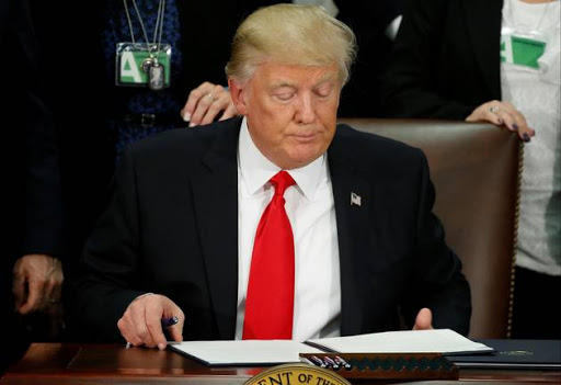 U.S. President Donald Trump reads an executive order before signing it at Homeland Security headquarters in Washington, U.S., January 25, 2017. REUTERS/Jonathan Ernst