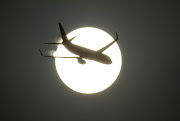 An aircraft is silhouetted by the sun