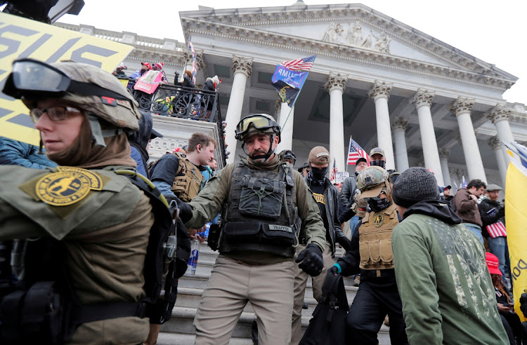 Jessica Marie Watkins (Left) and Donovan Ray Crowl (Center), both from Ohio, march down the East front steps of the US Capitol with the Oath Keepers militia group among supporters of US President Donald Trump protesting against the certification of the 2020 US presidential election results by the US Congress, in Washington on January 6 2021.