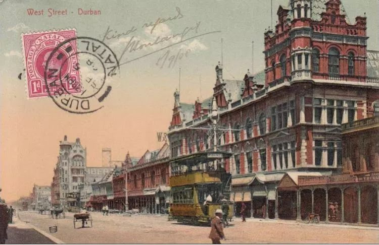West Street, Durban, showing the Point electric tram passing the departmental store ‘Harvey Greenacres’.