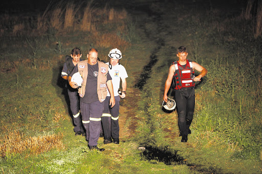 Rescuers temporarily call off a search for a six-year-old boy who is suspected to have drowned in a fast-flowing stream in Eldorado Park last night Picture: ALON SKUY