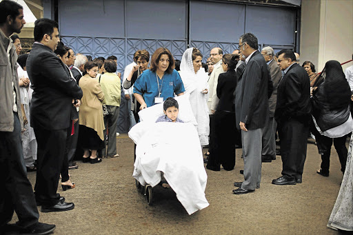 TRAGIC: Alyaz Merali, 8, who was shot twice in the Nairobi attack, takes part in the funeral procession for his mother, Selima Merali, and sister Nuriana, 15, who were both killed.