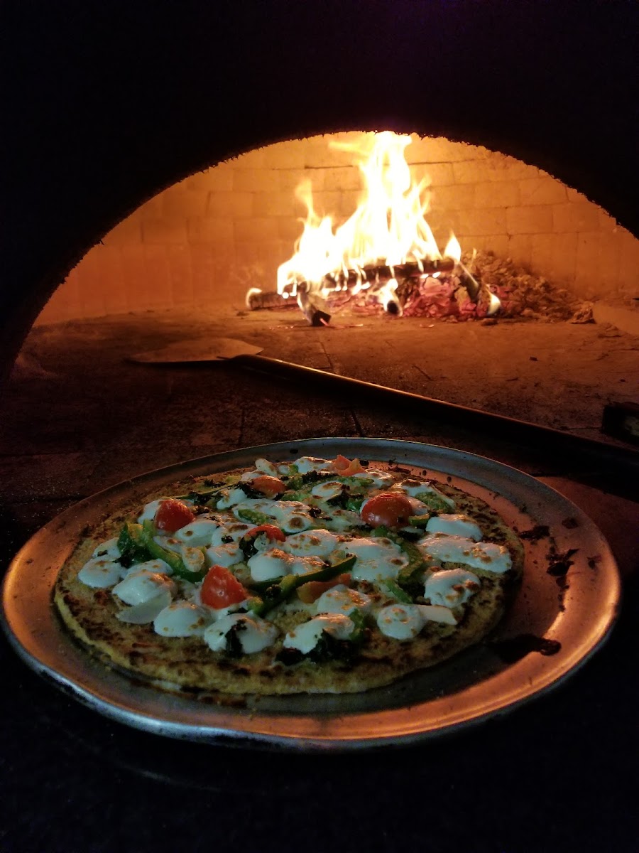 Delicious, gluten free Cauliflower Pizza made in a wood burning pizza oven.