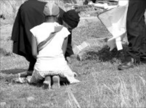 GRIEVING: Grandmother Veronica Seisa and a family member with her dead grandchild Thabo. © Unknown.