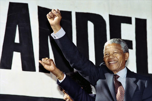 Anti-apartheid leader and African National Congress (ANC) member Nelson Mandela raises clenched fist, arriving at the "human rainbow" music concert organised by local artists to celebrate ANC leader's release from 27 years of imprisonment on 11 February, at Ellis Park stadium in Johannesburg, on March 17, 1990.