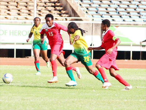 Cameroon Ngo Mbeleck Genevieve dribbles between Starlet Wendy Asol and Kinuthia Mary g.jpg