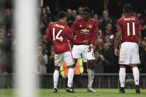 Manchester United's French midfielder Paul Pogba (C) and Manchester United's English midfielder Jesse Lingard (L) do a celebration dance after Pogba scored their third goal during the UEFA Europa League group A football match between Manchester United and Fenerbahce at Old Trafford in Manchester, north west England, on October 20, 2016.