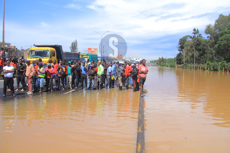 Onlookers stand along the flooded area of Thika Road at Jomo Kenyatta University on May 1, 2024.