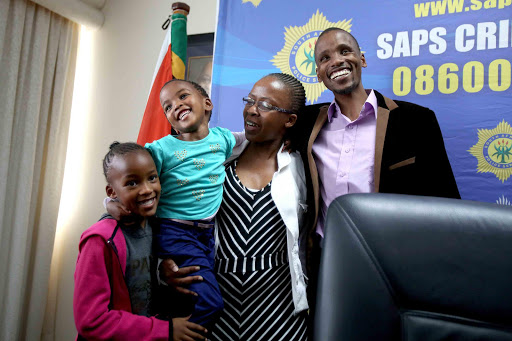 FULL OF SMILES: Perfect Gift Msesiwe was happy to be reunited with her family after being taken to Mozambique and held for ransom by their domestic worker. With her is her mom Zolelwa, her father Siyabonga and her older sister Sinovuyo Picture: MARK ANDREWS