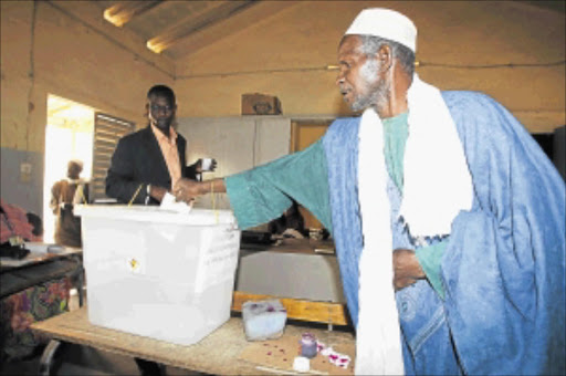 CHANGING TIMES: A man votes in Dakar during Senegal's election at the weekend. President Abdoulaye Wade admits he could face a runoff on Sunday, having defied warnings that his candidacy risks destabilising the historically tranquil country. photo: REUTERS