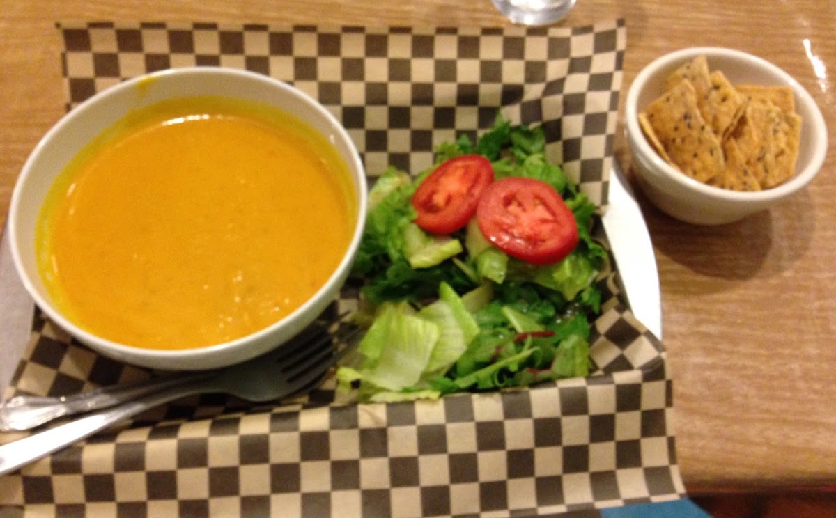 Bowl of Curried Squash Soup with a side salad and GF chips.