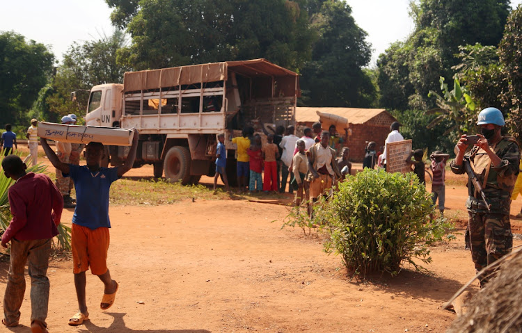 Civilians offload electoral materials from a United Nations Multidimensional Integrated Stabilization Mission in the Central African Republic (MINUSCA) truck, ahead of the upcoming elections in Yongofongo, Central African Republic on December 17, 2020.