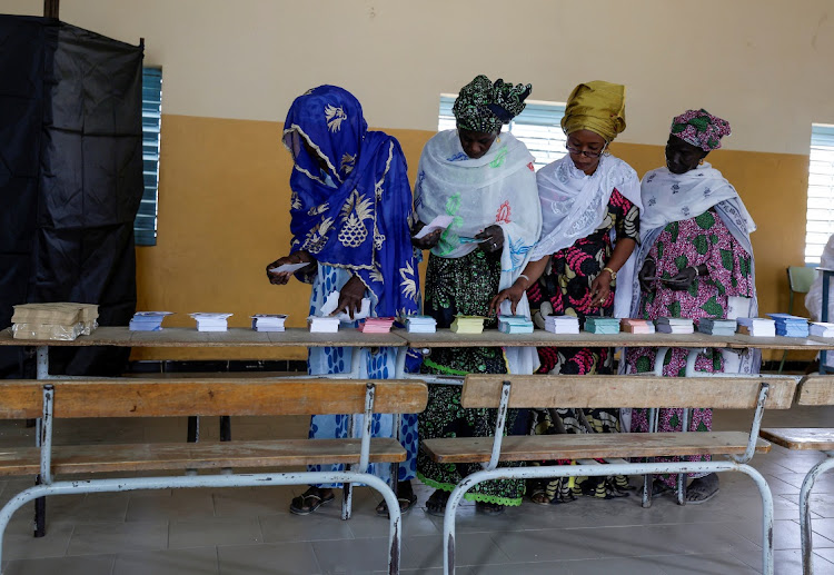 An election worker helps women to collect voting ballots at the polling station at Ndiaganiao in Mbour, Senegal March 24, 2024. Picture: ZOHRA BENSEMRA/REUTERS