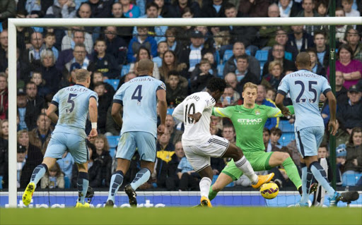 Swansea City's Ivorian striker Wilfried Bony (C) scores his team's first goal during the English Premier League football match between Manchester City and Swansea City at the The Etihad Stadium in Manchester, north west England, on November 22, 2014. AFP PHOTO / OLI SCARFF