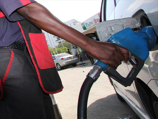An attendant fuelling a car.