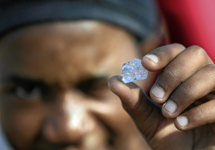 A man displays one of the shiny stones that diggers at KwaHlathi in KwaZulu-Natal initially believed to be diamonds.