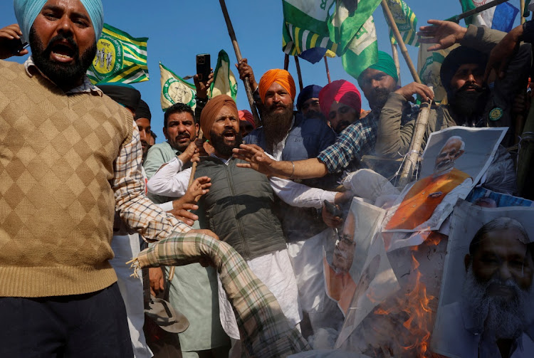 Farmers shout slogans as they burn an effigy of Prime Minister Narendra Modi and other ministers during a march towards New Delhi to push for better crop prices. Picture: ADRIAN ABIDI/REUTERS