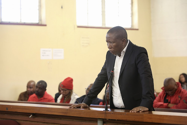 EFF leader Julius Malema stands in the dock in The Newcastle Magistrates court where he faces criminal charges relating to alleged contravention of the Riotous Assemblies Act.