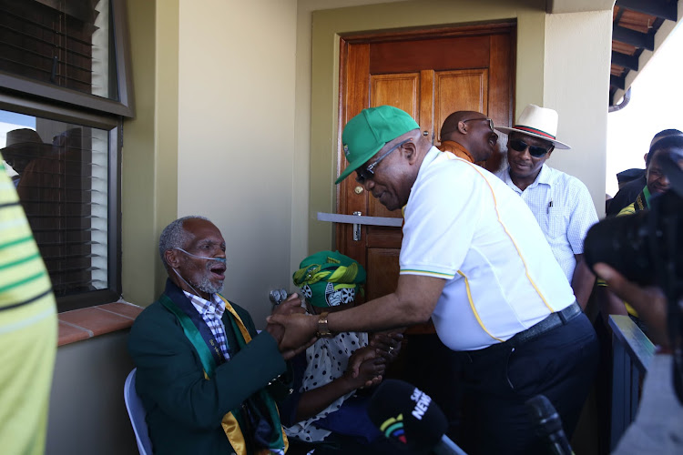 Former president Jacob Zuma greets struggle veteran Amos Ndwalane during the handing over of his new house in Lamontville in Durban in May.