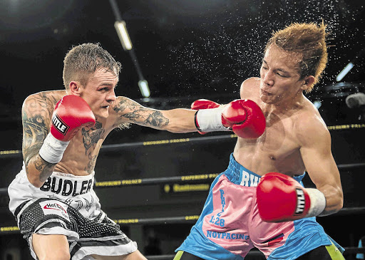 POWER OF THE GLOVE: South Africa's Hekkie Budler rocks Joey Canoy from the Philippines with a punch during their fight for the vacant IBO junior light flyweight title at Emperors Palace on the East Rand at the weekend