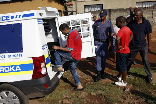 Foreign national shop owners being escorted by police out of Chiawelo on January 22, 2015 in Soweto. File photo.