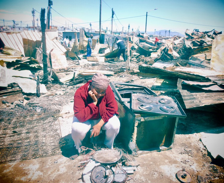 Fezeka Feni sits amongst the ruins of her former home in Kosovo informal settlement in Philippi after a fire in the area.