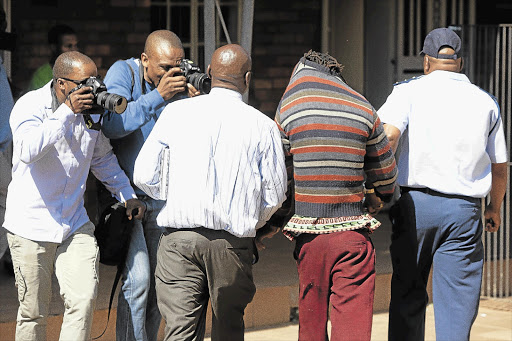 Press photographers try to get a picture of the man with whom the 17-year-old gang-rape victim was found in Soweto yesterday. She had been missing for weeks