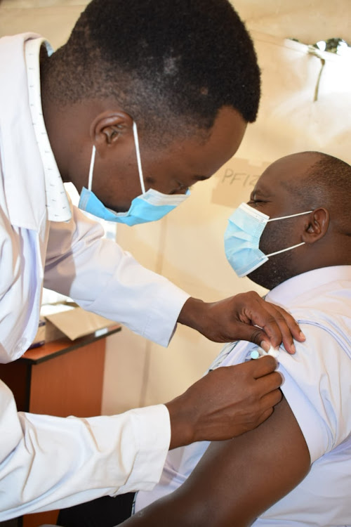 Nakuru Chief Officer for Public Health, Daniel Wainaina receives a COVIC-19 booster shot at the Rift Valley Provincial General Hospital,